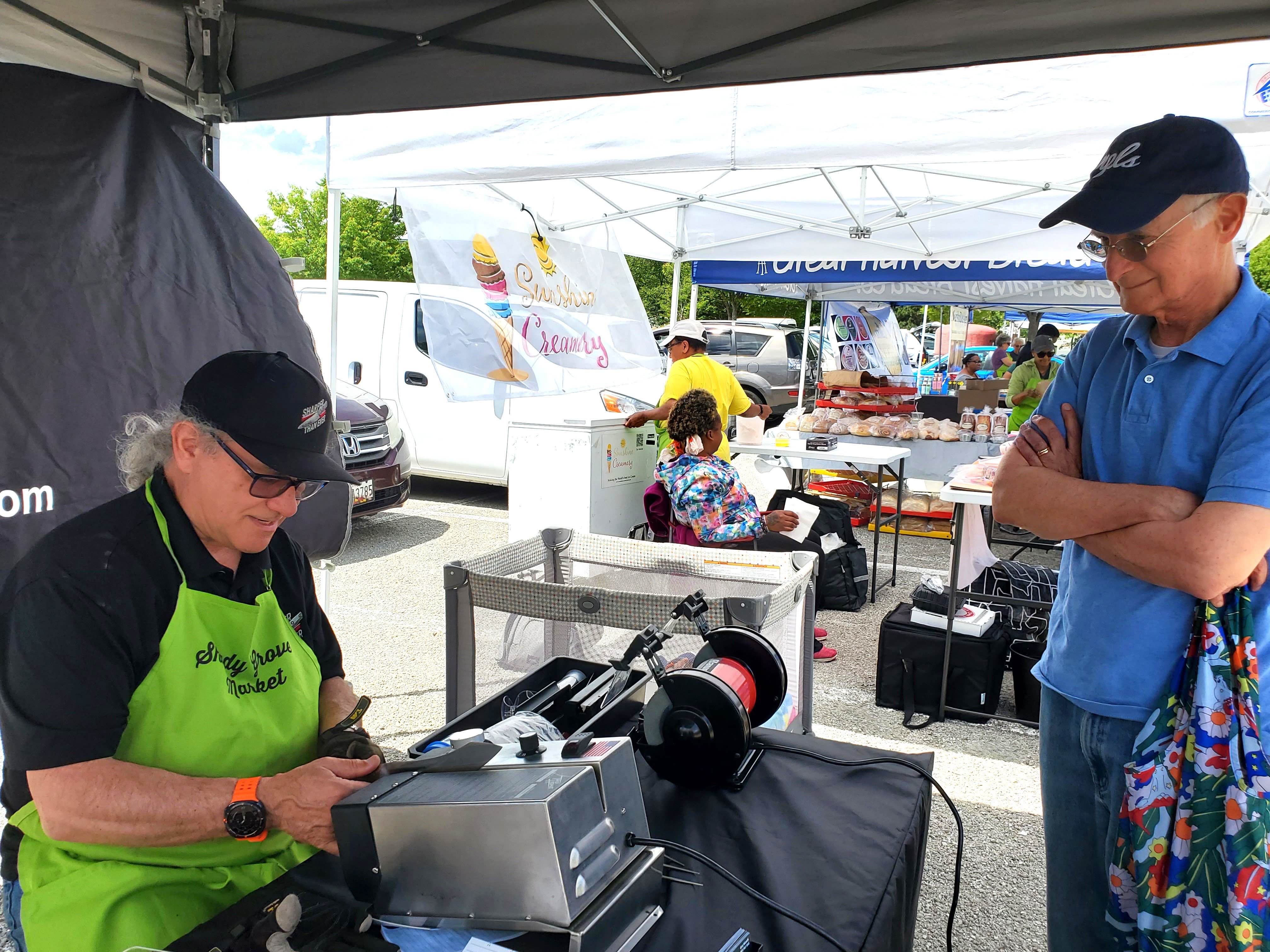 Gary demonstrating knife sharpening at farmers market